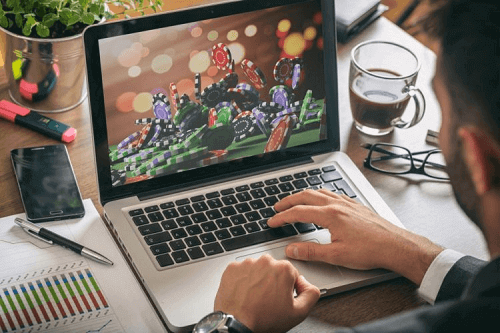 man at laptop playing casino game offshore
